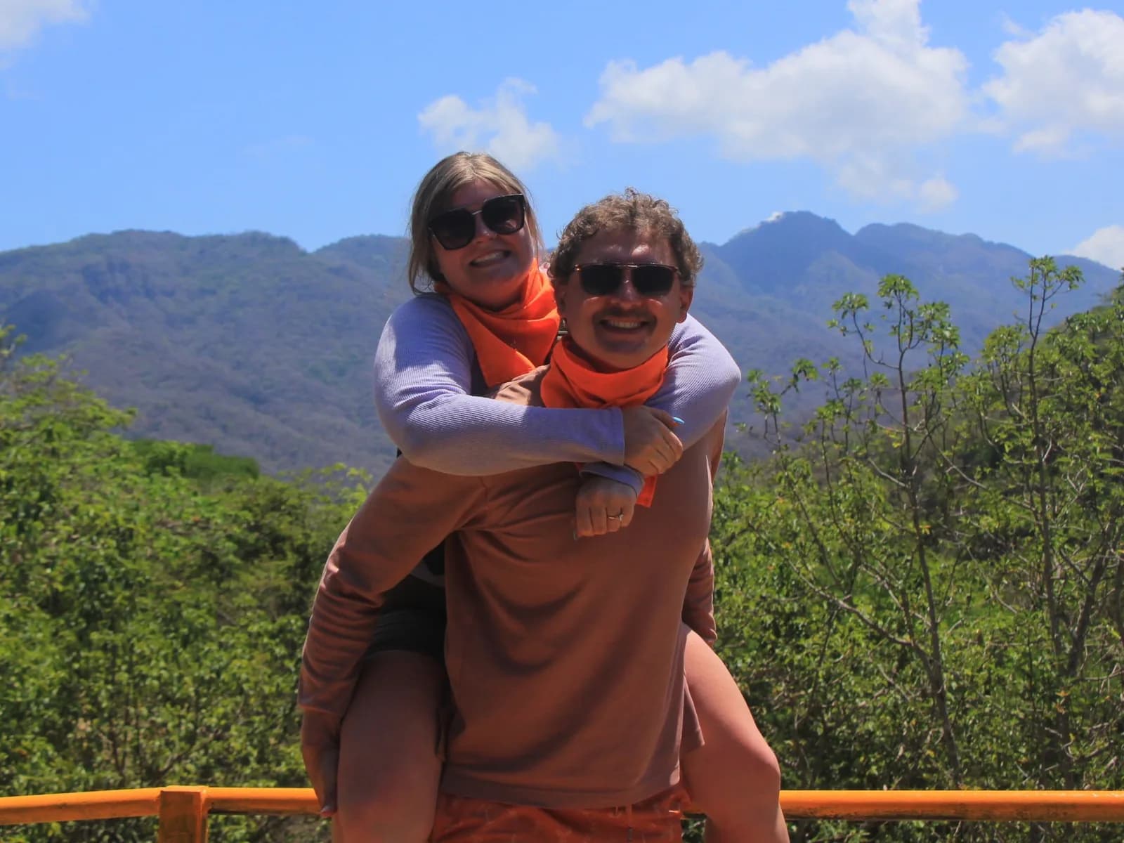 Dos visitantes en el mirador de la sierra, con la Sierra Madre al fondo